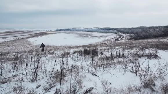 在冬季草原行走的男性旅行者视频的预览图