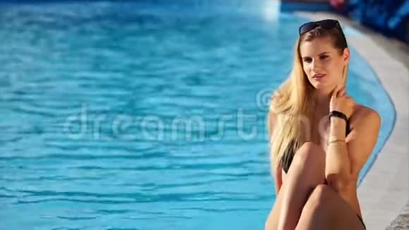 神奇的女人在游泳池附近晒日光浴视频的预览图