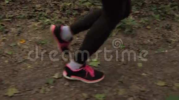 在林道奔跑的女运动员腿的特写视频的预览图