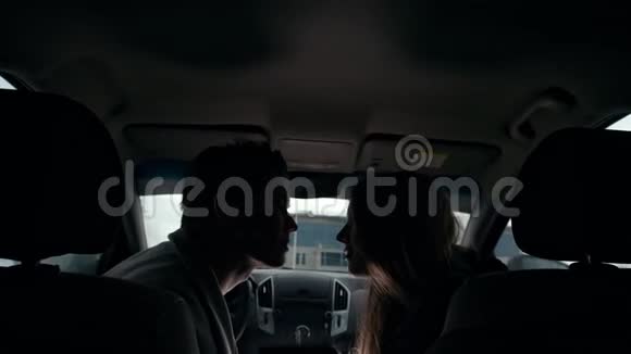 年轻可爱的情侣在车里拥抱亲吻视频的预览图