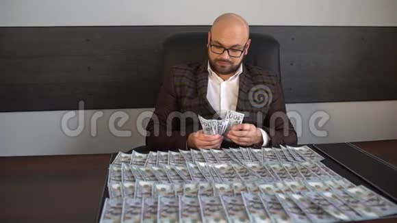 商人把钱和美元放在桌子上男人把美元放在桌子上特写男放了一叠视频的预览图
