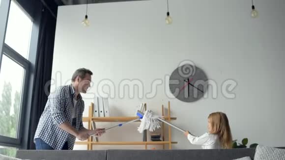 可爱的小女孩和她的父亲在公寓里打扫卫生时玩耍视频的预览图