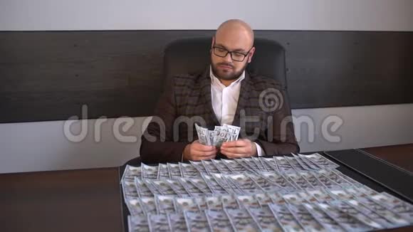 商人把钱和美元放在桌子上男人把美元放在桌子上特写男放了一叠视频的预览图