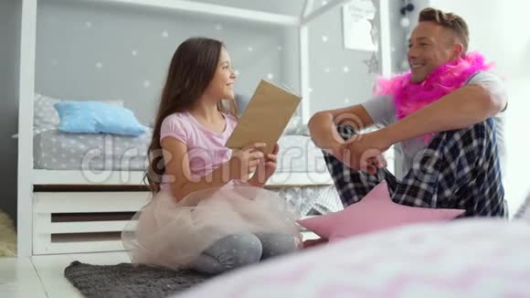 可爱的小女孩和她父亲一起读童话视频的预览图