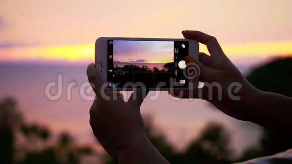 特写女手用电话拍摄风景秀丽的海上日落慢动作1920x1080视频的预览图