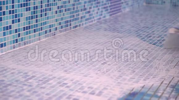 双手戴工作手套用海绵清洗游泳池翻新瓷砖上的奇数红色水泥胶视频的预览图