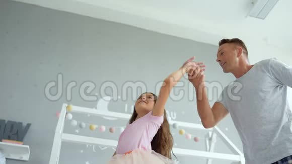 积极的爸爸和小女儿在家跳舞视频的预览图