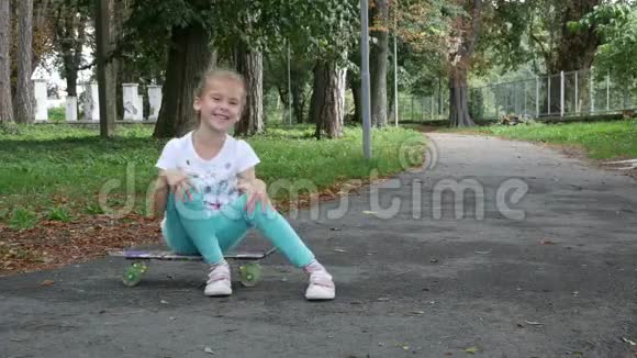 一个女孩坐在滑板上从一边骑到另一边视频的预览图