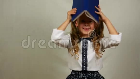 穿制服的少女在头上玩书小学生用打开的书盖住头视频的预览图