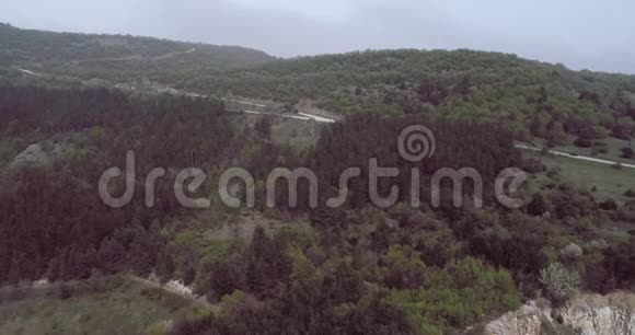 从弯曲的柏油路上俯瞰群山中的汽车视频的预览图
