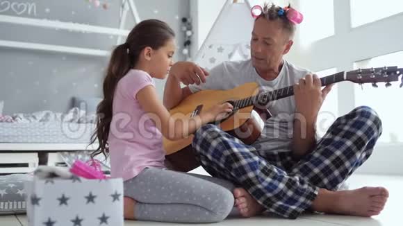 小女孩和她关心的父亲弹吉他视频的预览图
