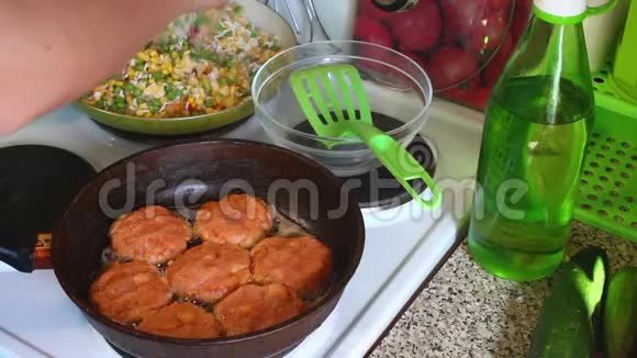 一个女人把蔬菜混合物倒入煎锅里煮旁边的煎锅炒肉丸从鲑鱼视频的预览图