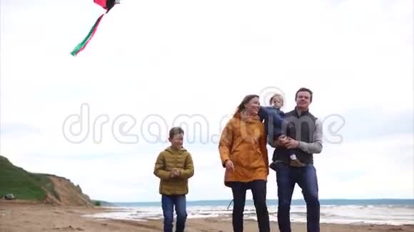 家人在海边散步男人女人男孩和小女孩视频的预览图