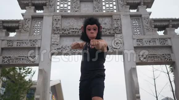 亚洲某地古寺前戴着猴子面具装着傻笑的成年人视频的预览图