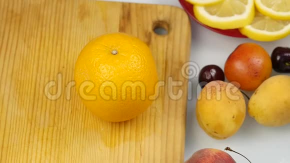 漂亮的女人在切割板上切新鲜的橙色水果做沙拉或榨汁减肥和节食的概念慢慢慢慢视频的预览图