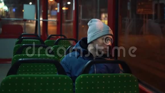 孤独的年轻人在夜晚乘坐电车视频的预览图