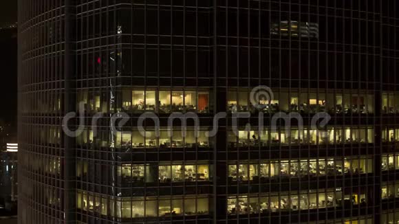 关闭摩天大楼的窗户在夜晚和人在里面夜间生活的概念库存为现代化的办公室服务视频的预览图