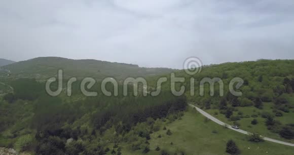 从弯曲的柏油路上俯瞰群山中的汽车视频的预览图