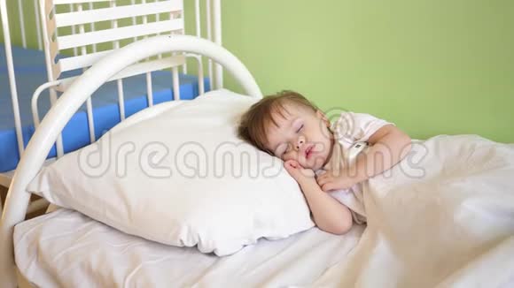 迷人的婴儿在家里的房间里的白色床上睡着了睡眠儿童的概念孩子想睡觉视频的预览图
