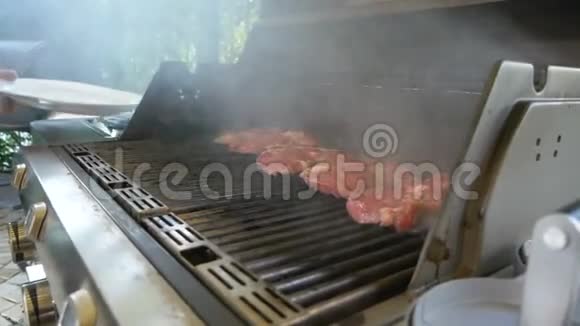 大型肉排在煤气烤架上烤制盘子里冒出一点烟专业烧烤视频的预览图