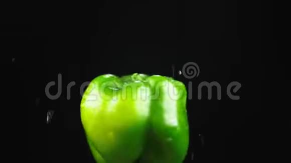 青椒特写水滴落在黑色背景上旋转的苹果上超级慢动作视频的预览图