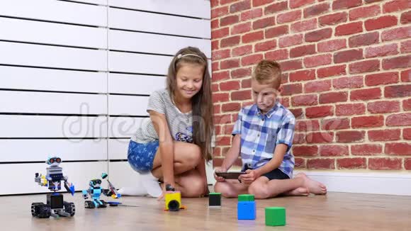 七岁的男孩和女孩在收音机上玩电子机器人汽车现代玩具新技术视频的预览图