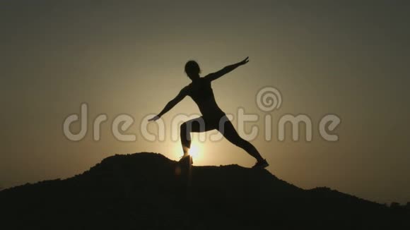 晚上独自在山顶练习瑜伽的女人剪影视频的预览图