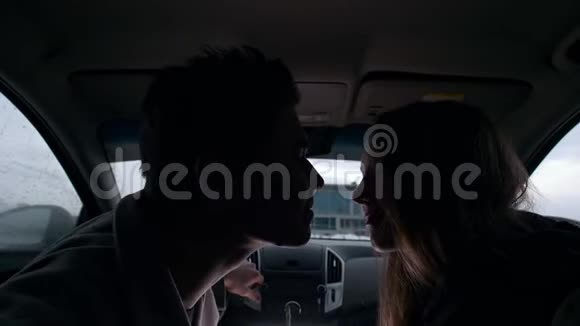 年轻可爱的情侣在车里拥抱亲吻视频的预览图