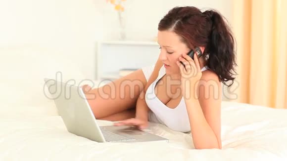 活跃的女人在打电话时使用她的笔记本电脑视频的预览图