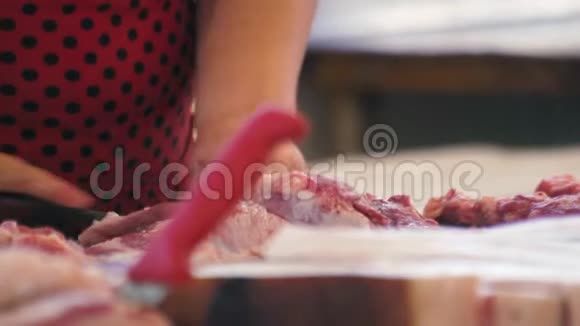 女人在市场上切鲜肉胖特写屠夫商店视频的预览图