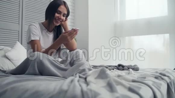 快乐的年轻女人在床上聊天视频的预览图