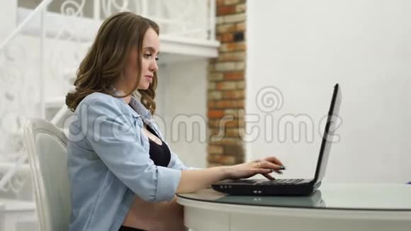 孕妇在产假期间从事业务坐在电脑前抚摸着她的肚子和她说话视频的预览图