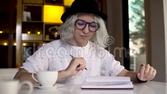 戴帽子的女性写日记日记视频的预览图