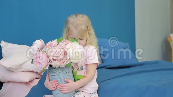 小女孩拿着一个大花瓶放在床上的房间里视频的预览图