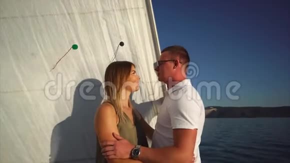 快乐的年轻恋人在阳光明媚的日子拥抱在游艇上视频的预览图