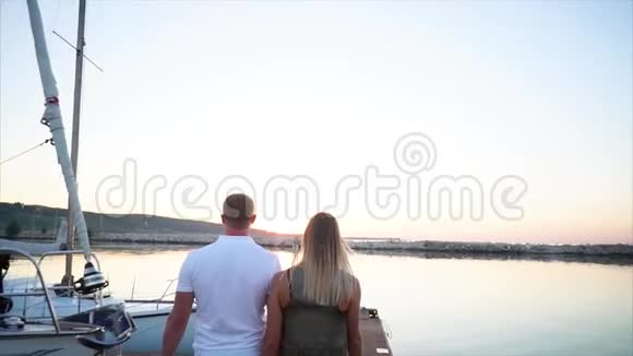 年轻的已婚夫妇晚上在码头上散步后景视频的预览图