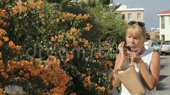 年轻女子在口袋镜子前准备把太阳镜戴在脸上视频的预览图