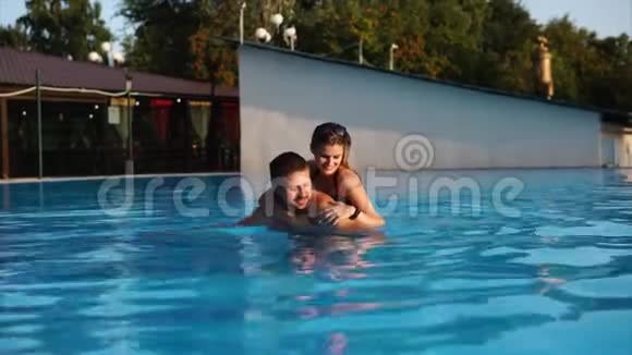 一对情侣正在户外酒店的一个空的大游泳池里游泳视频的预览图