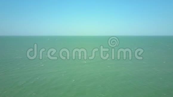 在蔚蓝的天空下飞翔在无边的绿松石海上视频的预览图