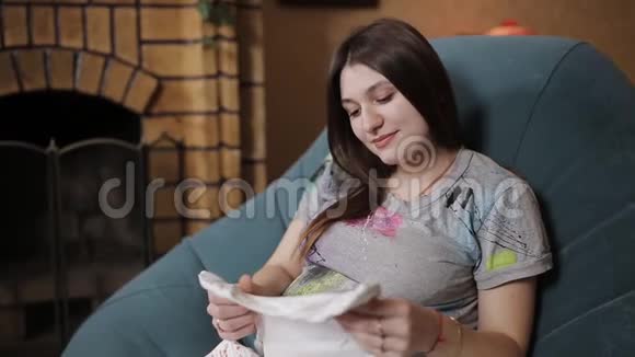 怀孕的母亲和幸福的父亲看着婴儿衣服视频的预览图