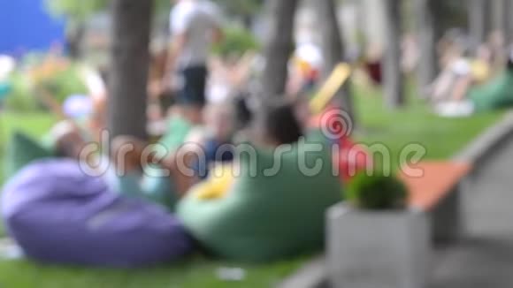 背景人们在公园里的包椅扶手椅袋里休息视频的预览图