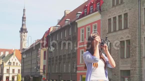 迷人的年轻女孩旅行和探索美丽的古镇带复古相机的游客视频的预览图