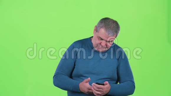 男人在智能手机上自拍绿色屏幕视频的预览图