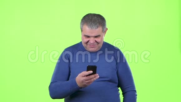 成年男子正在看电话留言绿色屏幕慢动作视频的预览图