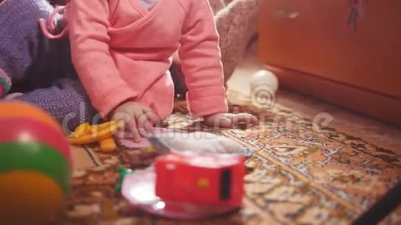 小女孩和她的祖母坐在地上玩着五颜六色的玩具视频的预览图