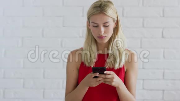 金发女人用智能手机视频的预览图