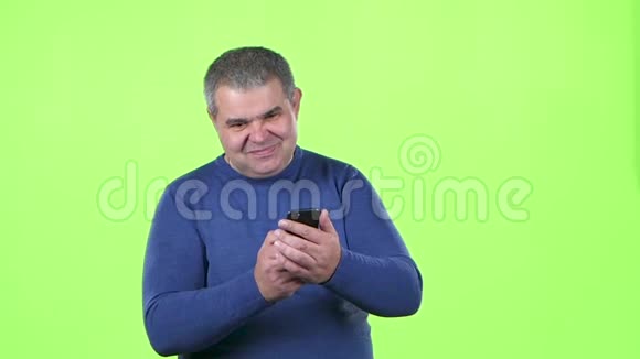 男人正在看电话留言绿色屏幕慢动作视频的预览图