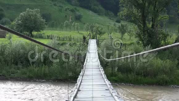 悬索式乡村木桥横跨山河田园绿色自然视频的预览图