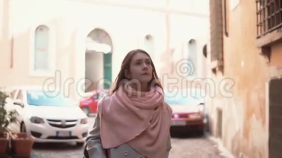 旅行女孩带着背包走过小街年轻的女人探索旧城环顾四周视频的预览图