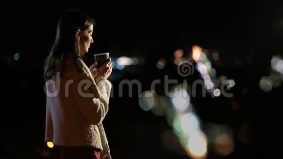 美丽的女人享受夜晚的城市灯光视频的预览图